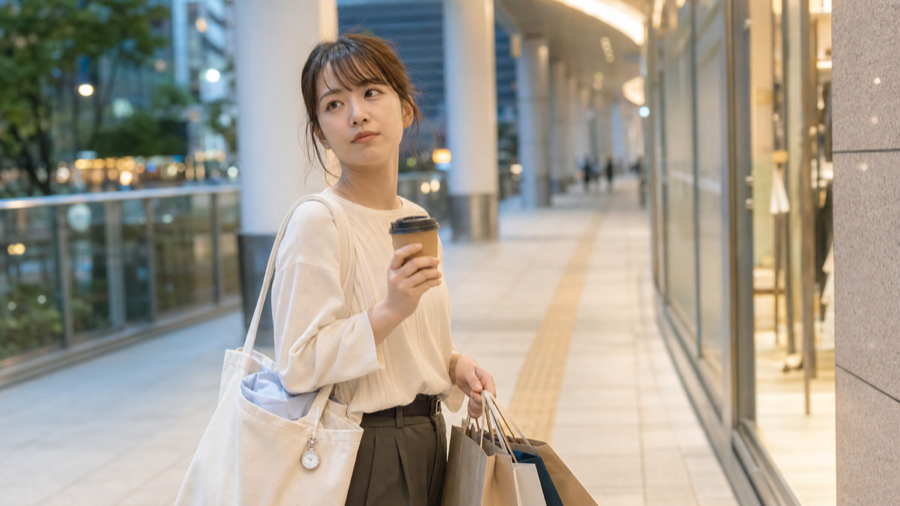 買い物袋を持って帰る若手看護師